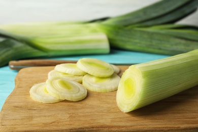 Fresh raw leek on cutting board, closeup. Ripe onion