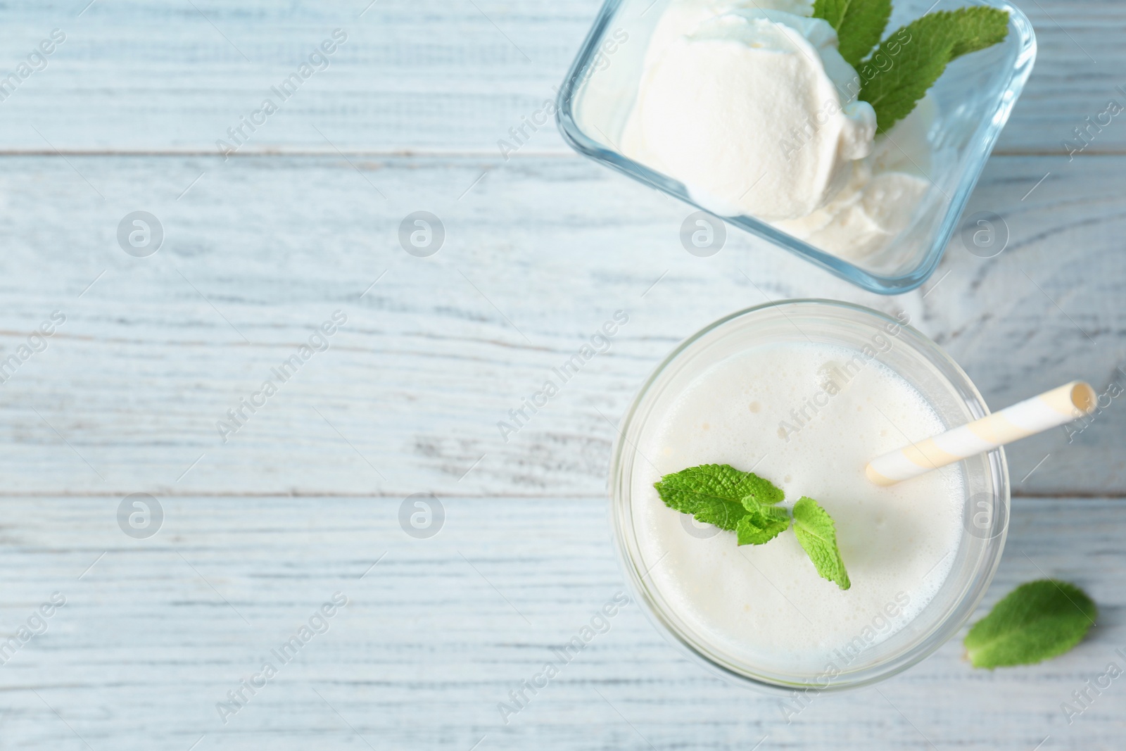 Photo of Glass with milk shake and tasty vanilla ice cream on wooden background