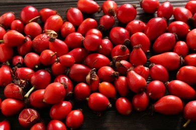 Photo of Fresh ripe rosehip berries on wooden table, closeup