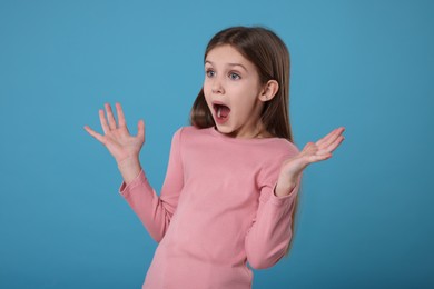 Photo of Portrait of surprised girl on light blue background