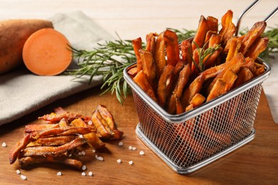 Sweet potato fries and rosemary on wooden table, closeup