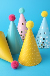 Photo of Colorful party hats on light blue background