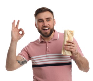 Young man with delicious shawarma on white background