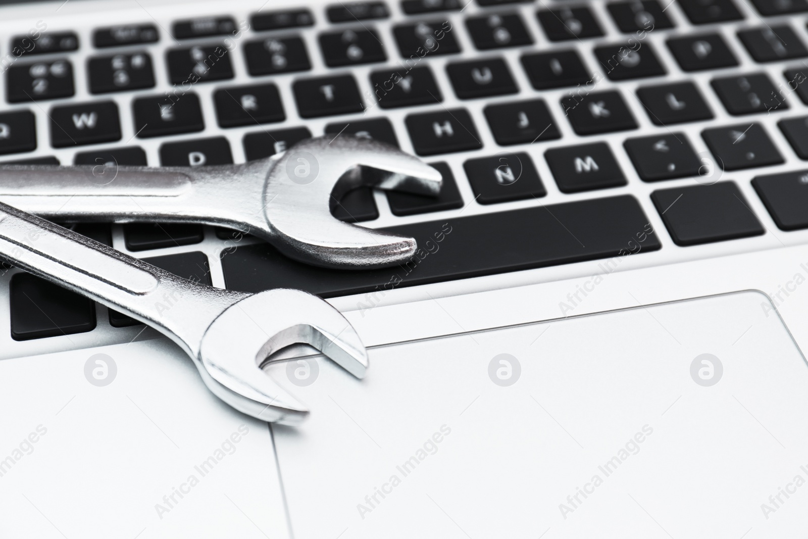 Photo of Wrenches on computer keyboard. Concept of technical support