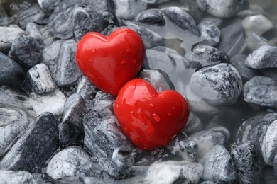 Red decorative hearts on stones and water