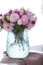 Photo of Vase with beautiful chrysanthemum flowers on countertop in kitchen. Interior design