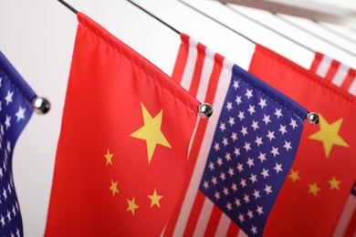 Photo of USA and China flags on white background, closeup. International relations