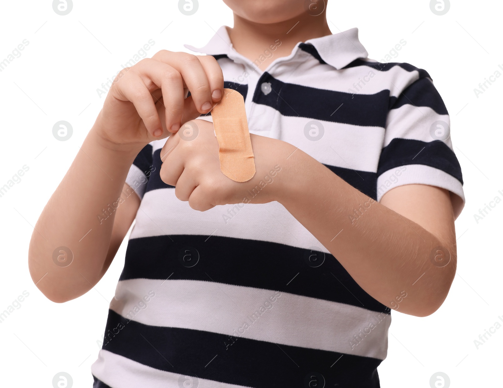 Photo of Little boy putting sticking plaster onto hand on white background, closeup