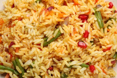 Photo of Tasty rice pilaf with vegetables as background, closeup