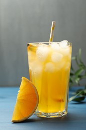 Photo of Delicious orange soda water on blue wooden table
