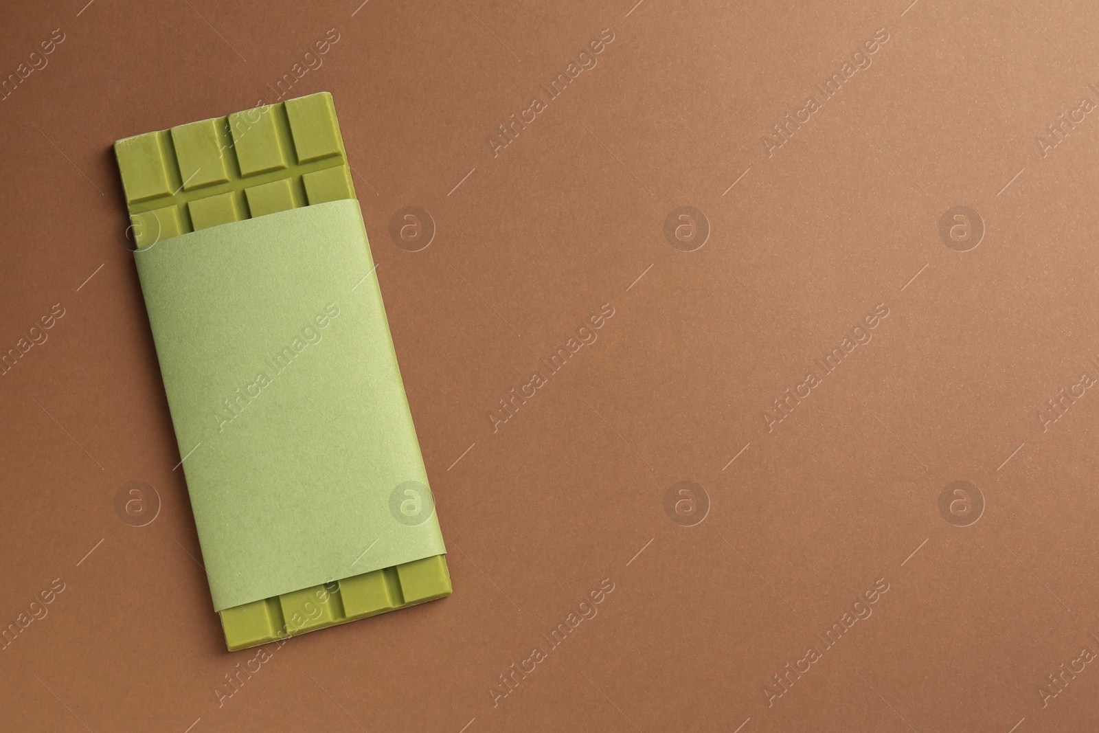 Photo of Tasty matcha chocolate bar on brown background, top view. Space for text