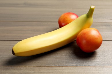 Photo of Banana and nectarines symbolizing male genitals on wooden table. Potency concept