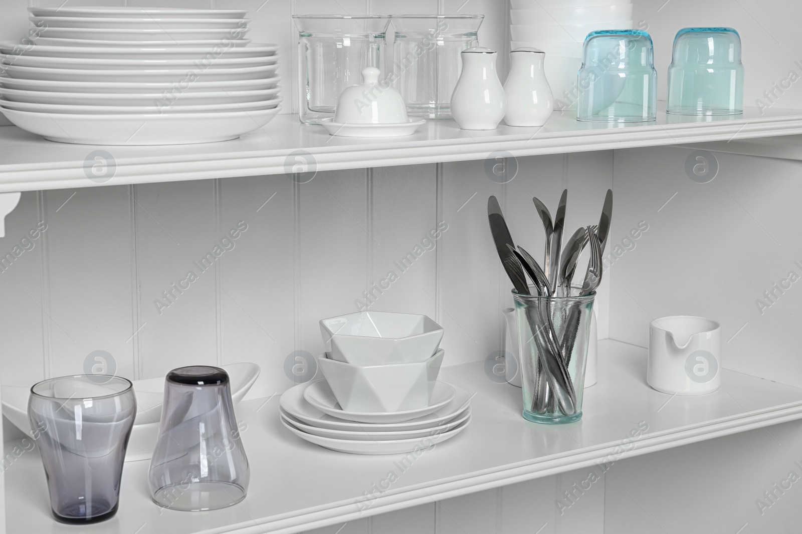 Photo of White shelving unit with set of dishware