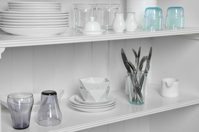 Photo of White shelving unit with set of dishware