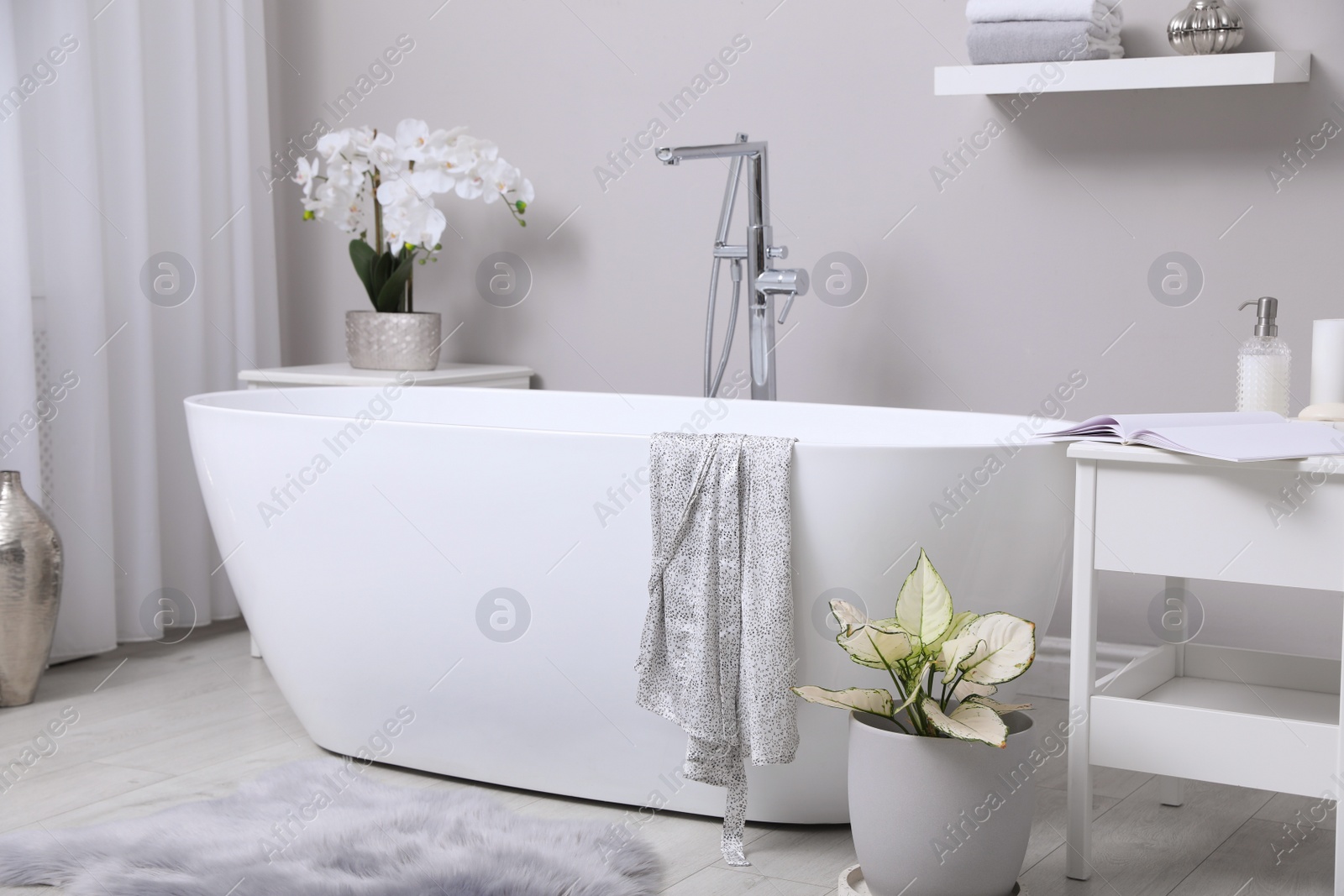 Photo of White tub and beautiful plants in bathroom, Interior design