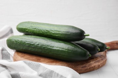 Fresh cucumbers on white tiled table, closeup