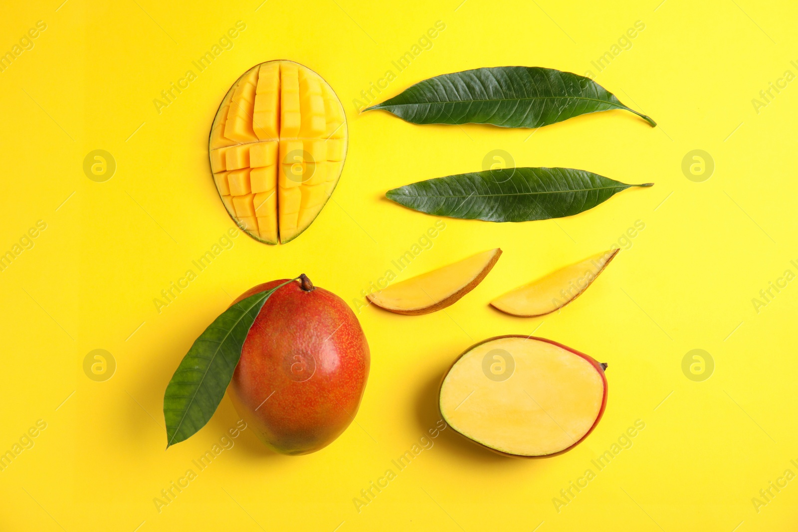 Photo of Flat lay composition with ripe mangoes and leaves on color background