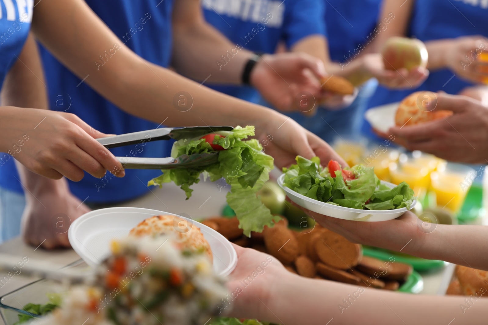 Photo of Volunteers serving food to poor people, closeup