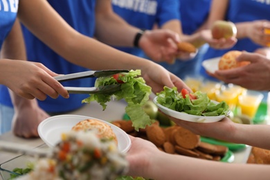 Volunteers serving food to poor people, closeup