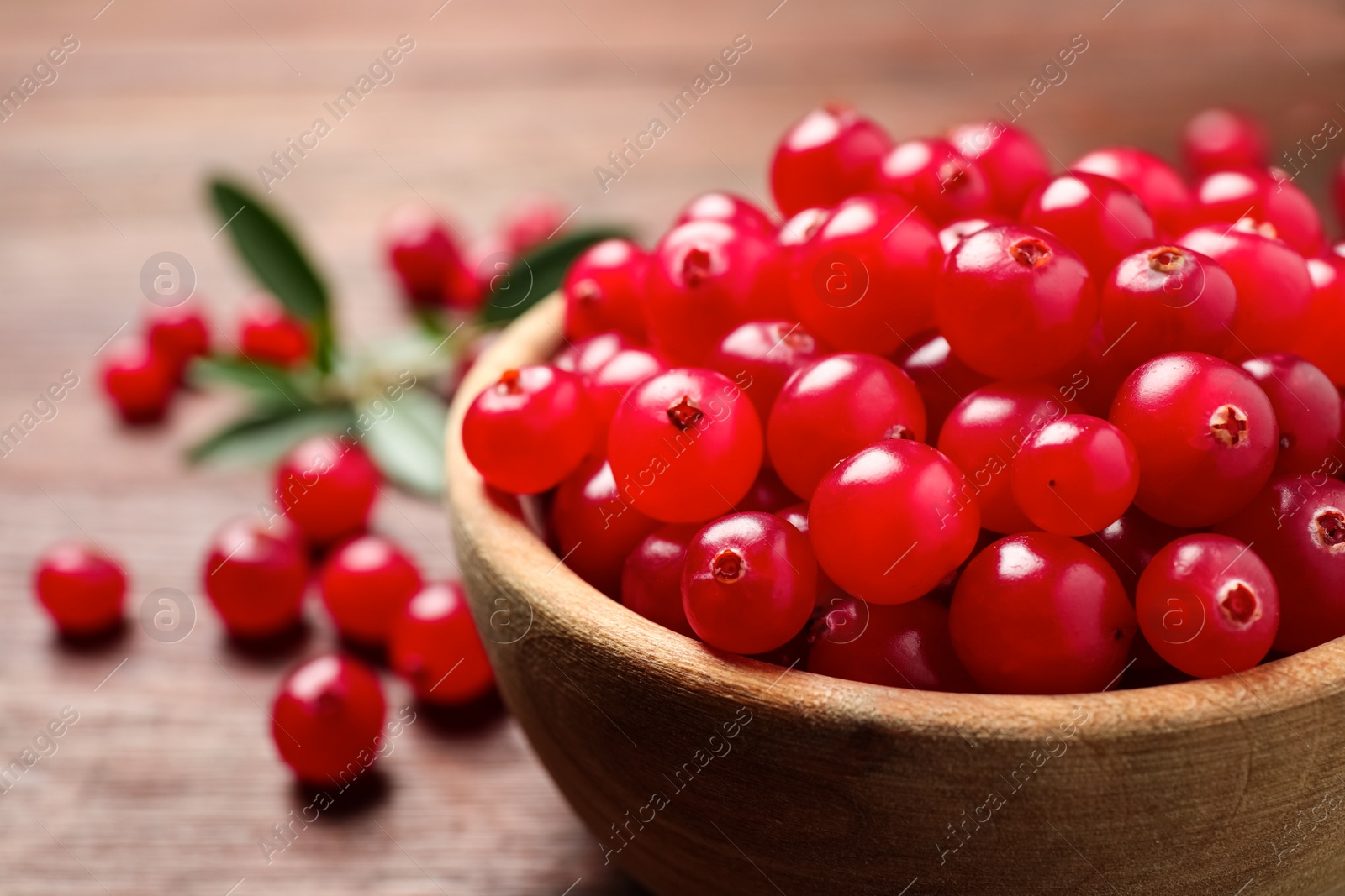 Photo of Tasty ripe cranberries on brown table, closeup