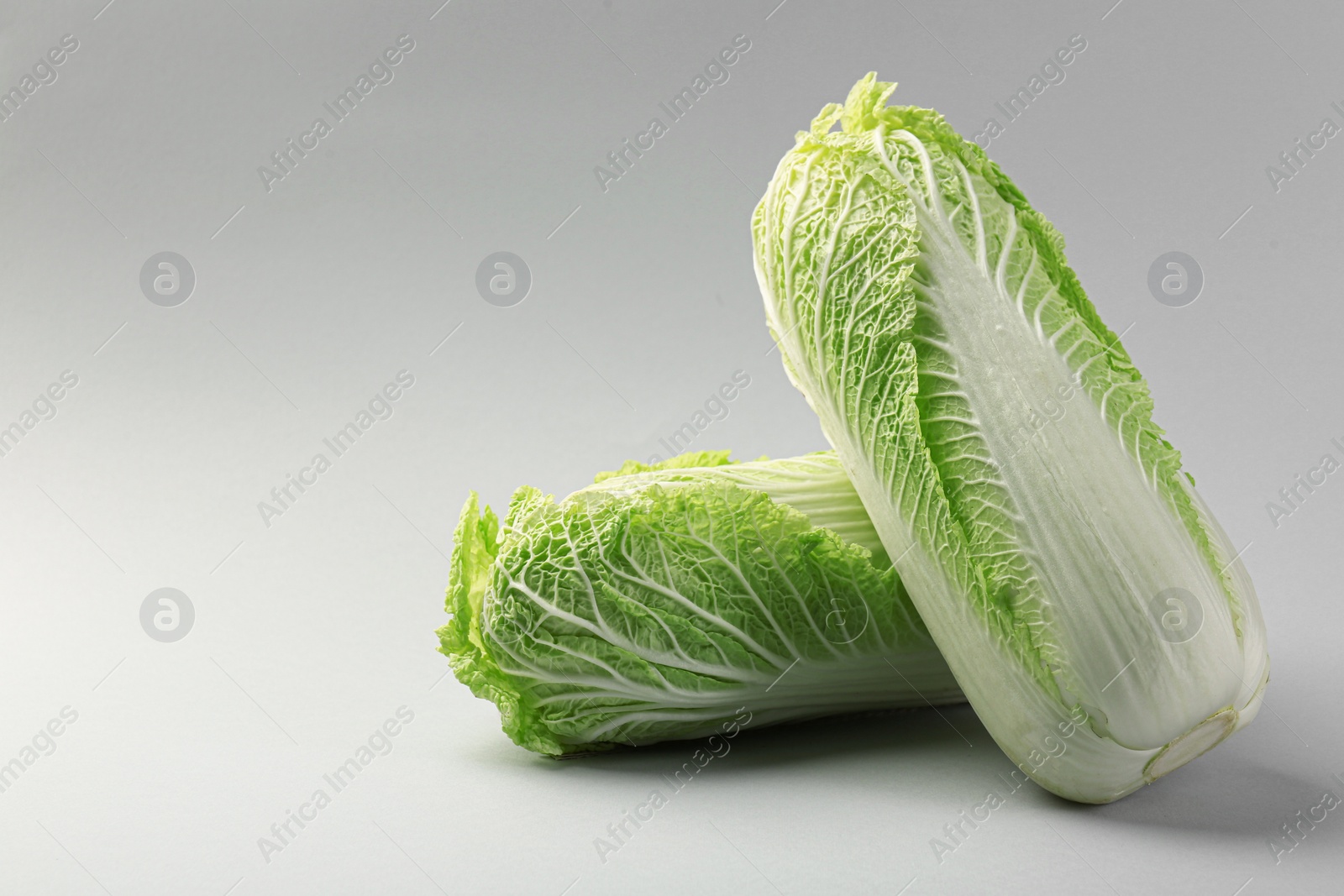 Photo of Fresh ripe Chinese cabbages on light grey background