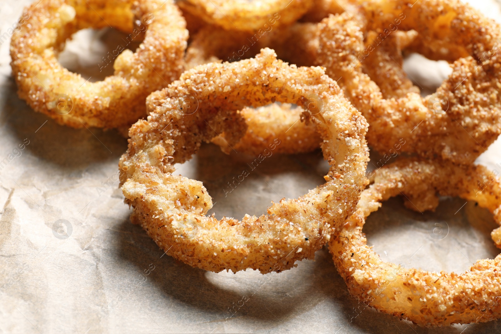 Photo of Parchment paper with homemade crunchy fried onion rings, closeup
