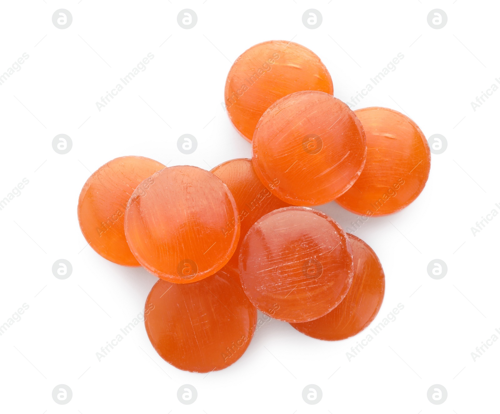 Photo of Many orange cough drops on white background, top view