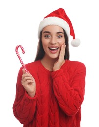 Photo of Excited young woman in red sweater and Santa hat holding candy cane on white background. Celebrating Christmas
