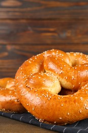 Tasty freshly baked pretzels on wooden table, closeup. Space for text