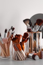 Photo of Set of professional brushes and mirror on wooden table