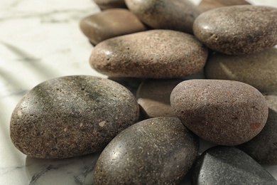 Photo of Pile of spa stones on marble table, closeup