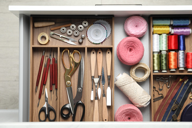 Photo of Sewing accessories in open desk drawer, top view