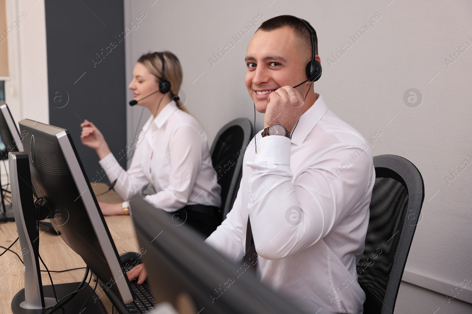 Photo of Call center operators with headsets working in modern office