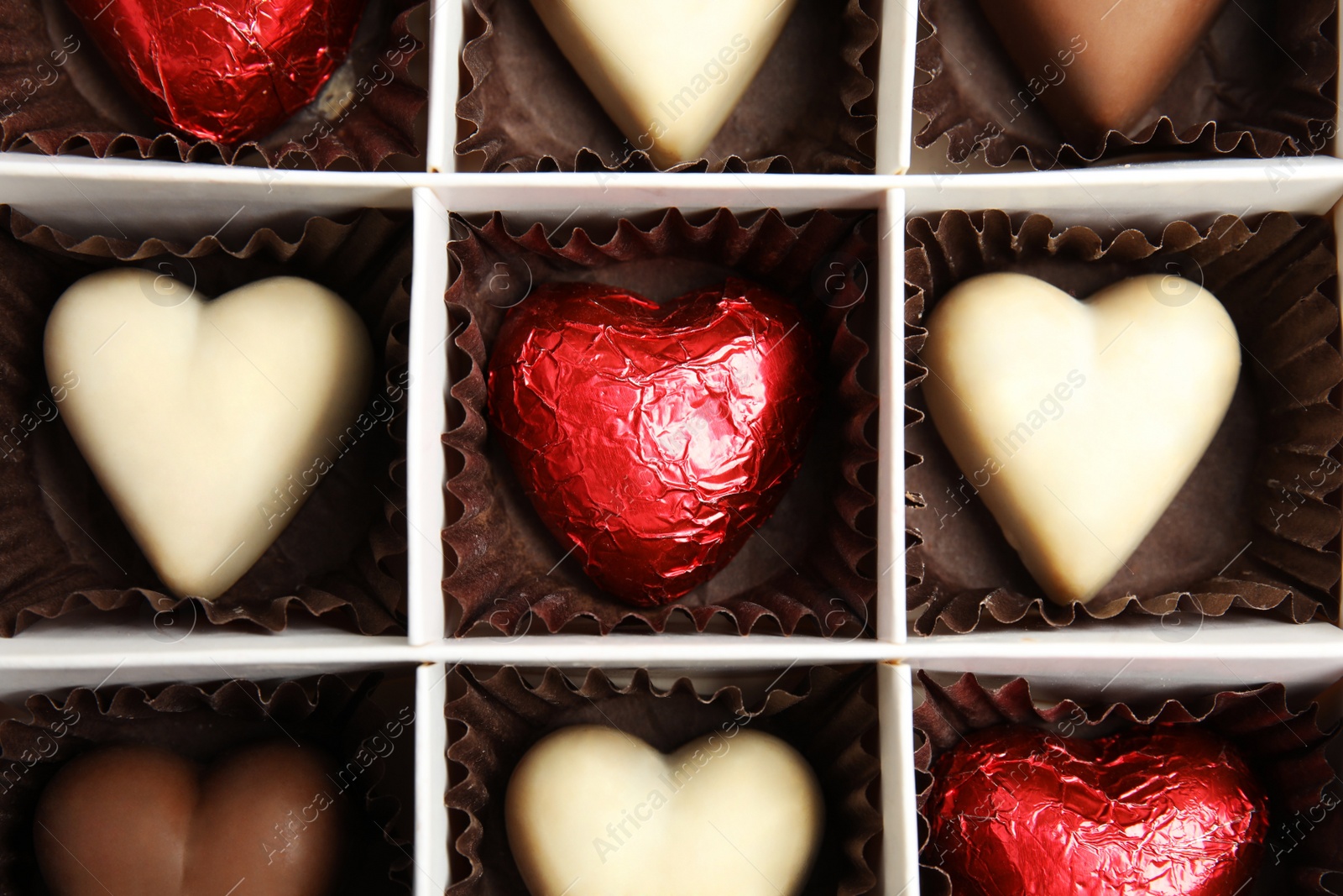 Photo of Tasty heart shaped chocolate candies in box, top view. Valentine's day celebration