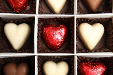 Tasty heart shaped chocolate candies in box, top view. Valentine's day celebration