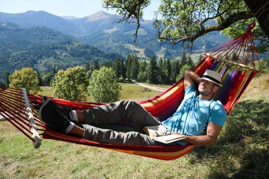 Man resting in hammock outdoors on sunny day