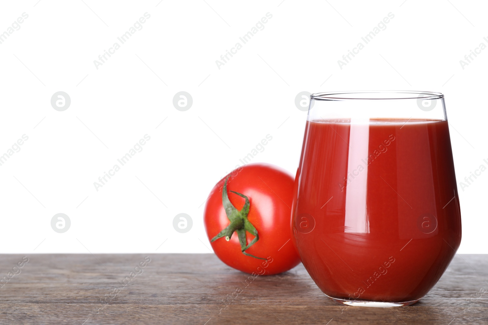 Photo of Glass of delicious juice and fresh tomato on wooden table against white background. Space for text