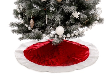 Photo of Decorated Christmas tree with red skirt on white background