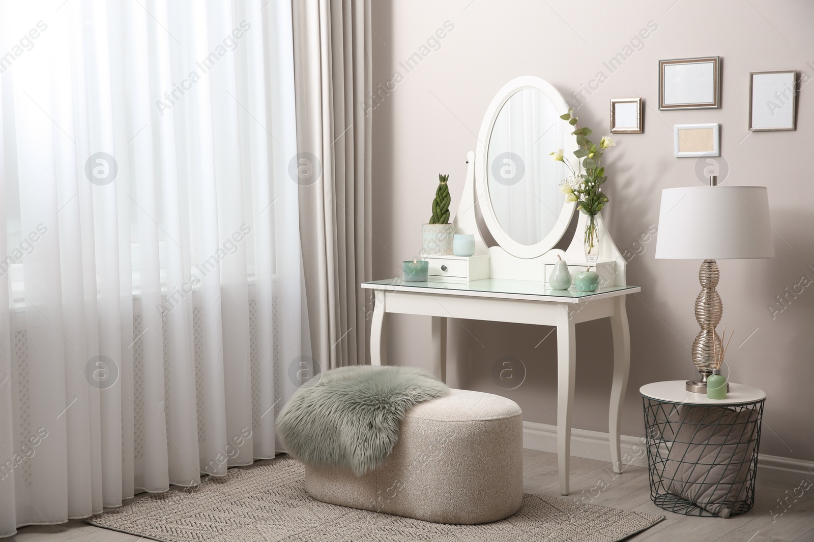 Photo of White dressing table with decor near window in room