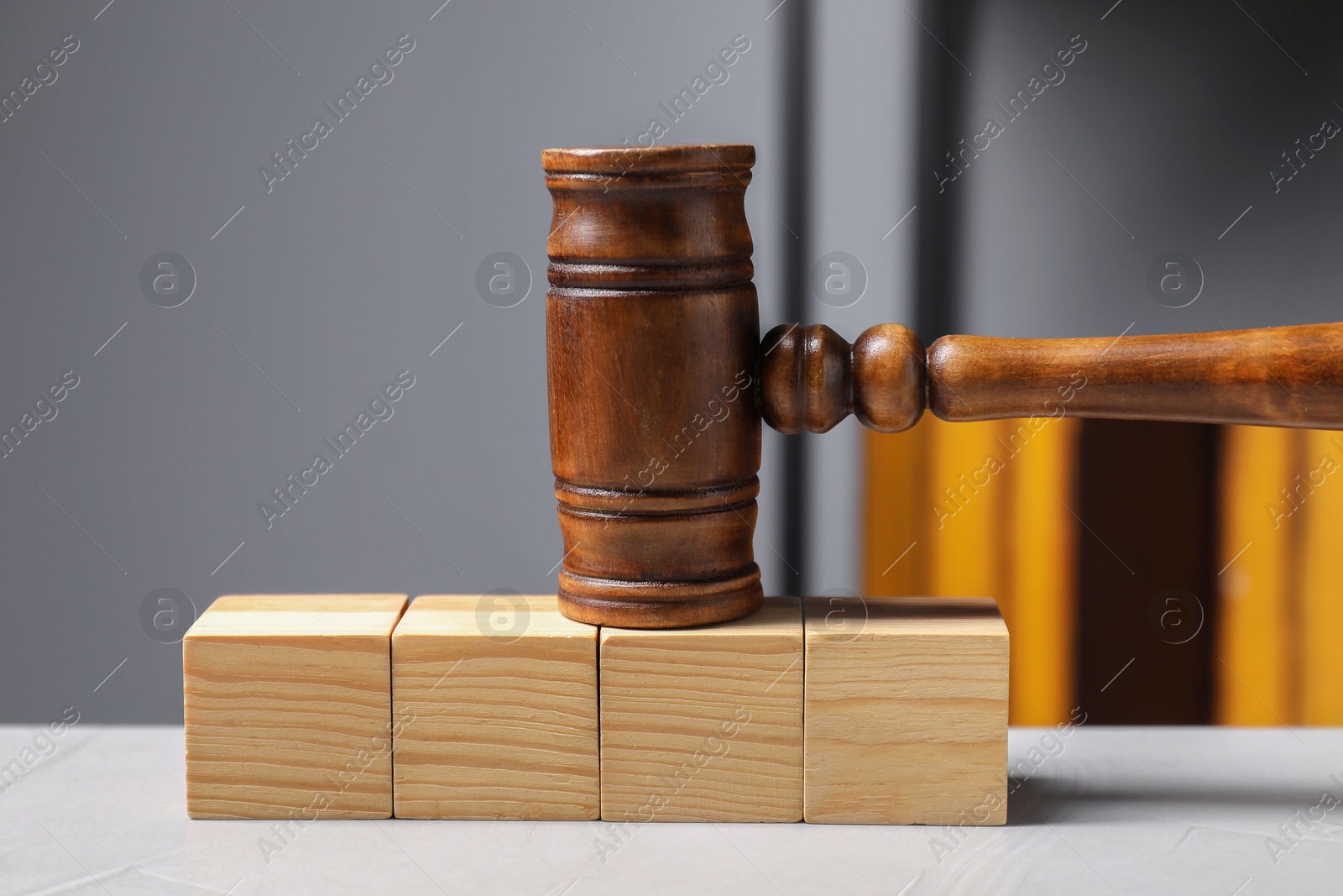 Photo of Law. Blank wooden cubes and gavel on light table against gray background