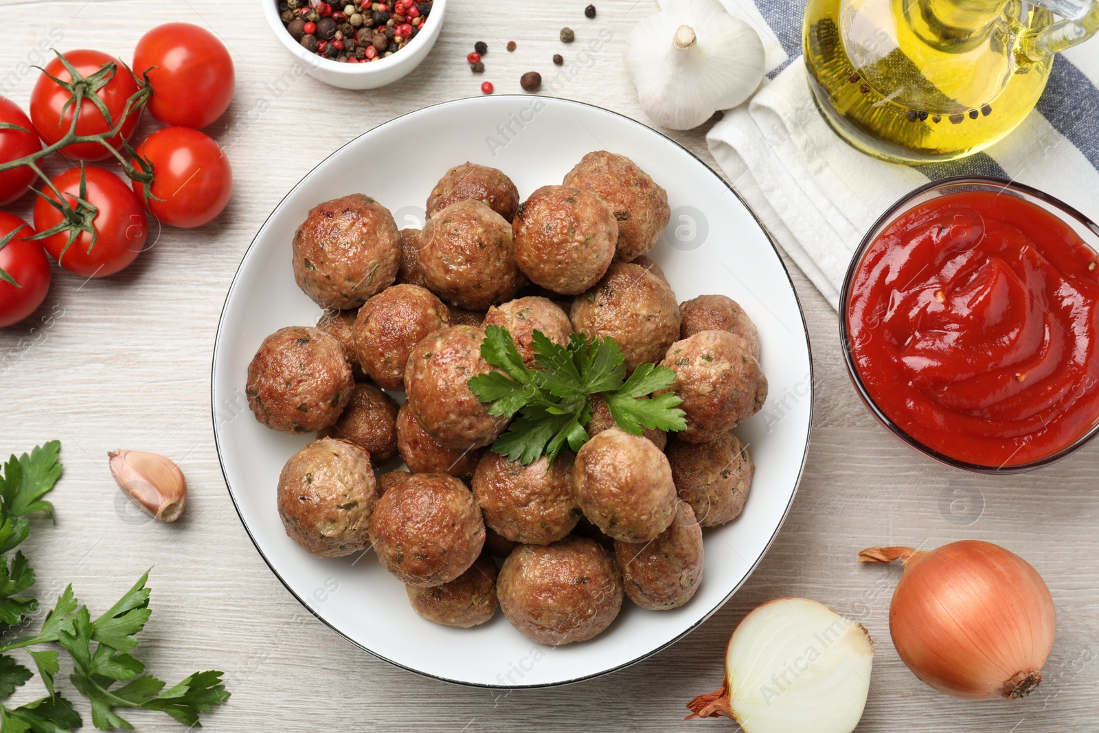 Photo of Tasty cooked meatballs with parsley on white wooden table, flat lay