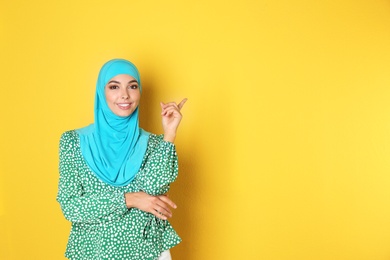 Photo of Portrait of young Muslim woman in hijab against color background. Space for text