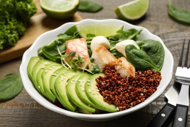 Photo of Delicious avocado salad with chicken on wooden table