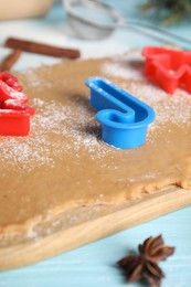 Photo of Making homemade Christmas cookies. Dough and cutters on table, closeup