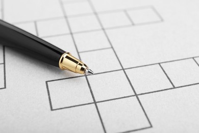 Photo of Pen on blank crossword, closeup. Space for text