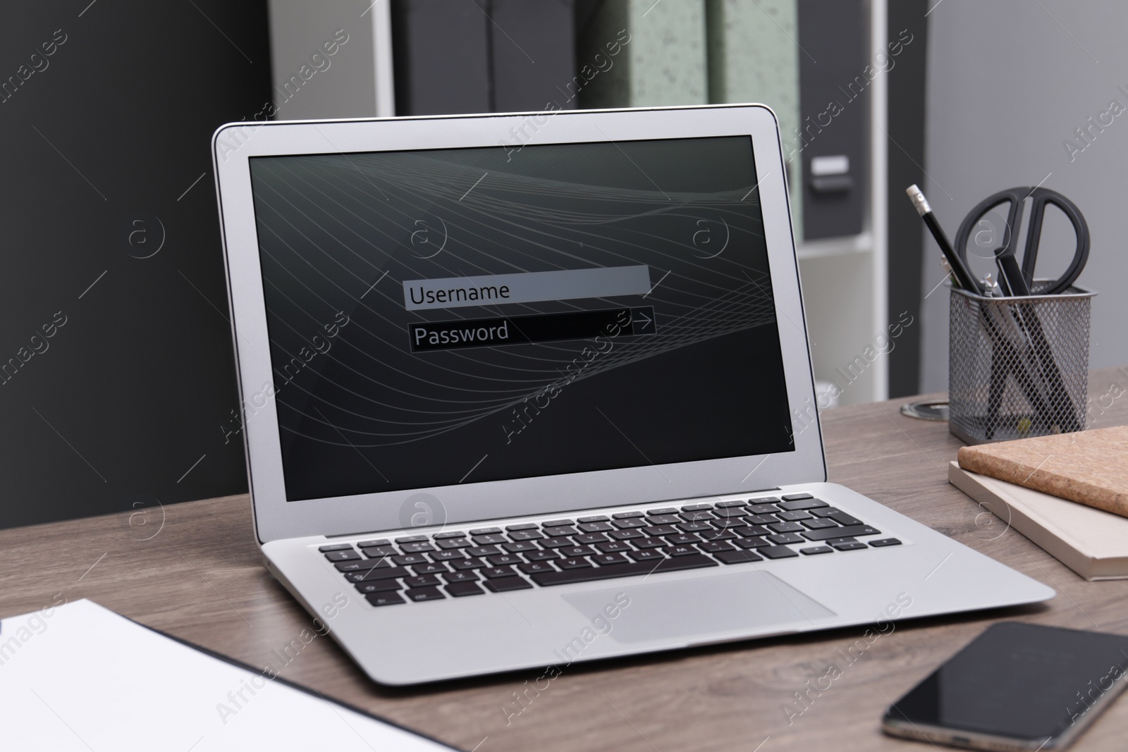 Photo of Modern laptop with blocked screen on wooden table in office