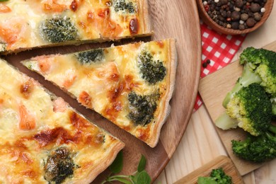 Delicious homemade quiche and ingredients on table, flat lay