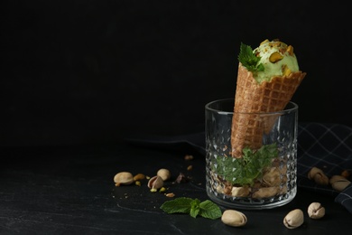 Photo of Delicious pistachio ice cream on dark table. Space for text