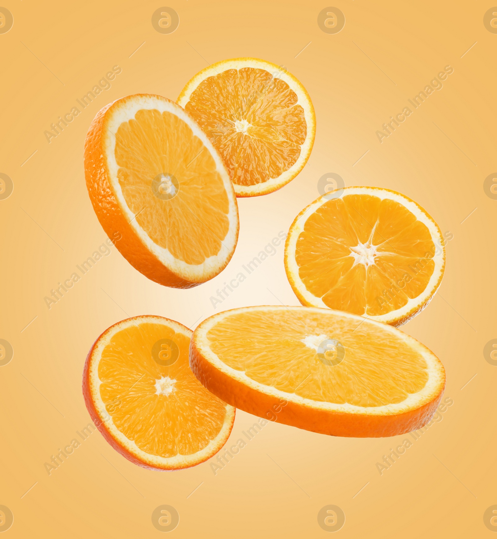 Image of Juicy orange slices flying on pale orange background