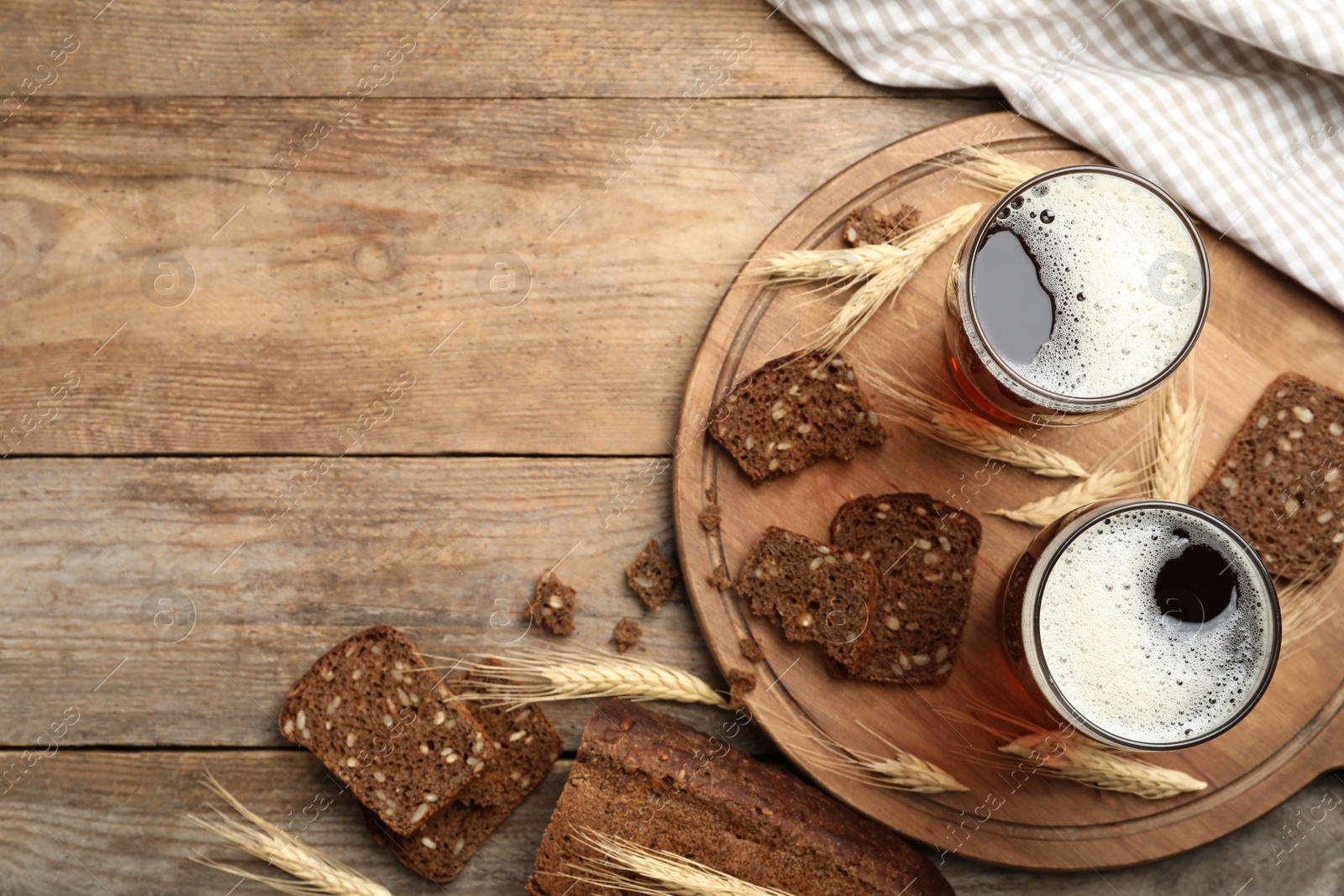 Photo of Delicious kvass, bread and spikes on wooden table, flat lay. Space for text